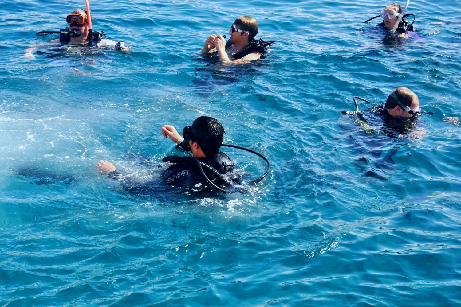 Viaje a Egipto 11 Días de Gran Lujo: Personas practicando buceo en el Mar Rojo, Hurghada, disfrutando de los arrecifes de coral y las actividades acuáticas durante el viaje por Egipto.