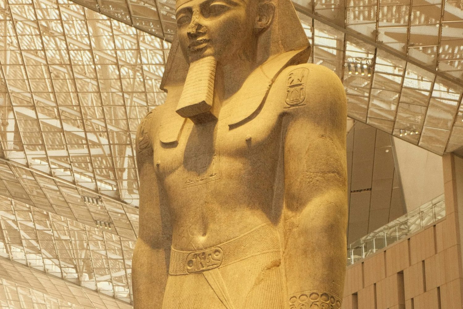 Excursión desde Luxor a Cairo en Avión Por un día: Estatua colosal de Ramsés II en el Gran Museo Egipcio, mostrando los detalles de su rostro y su imponente presencia faraónica.