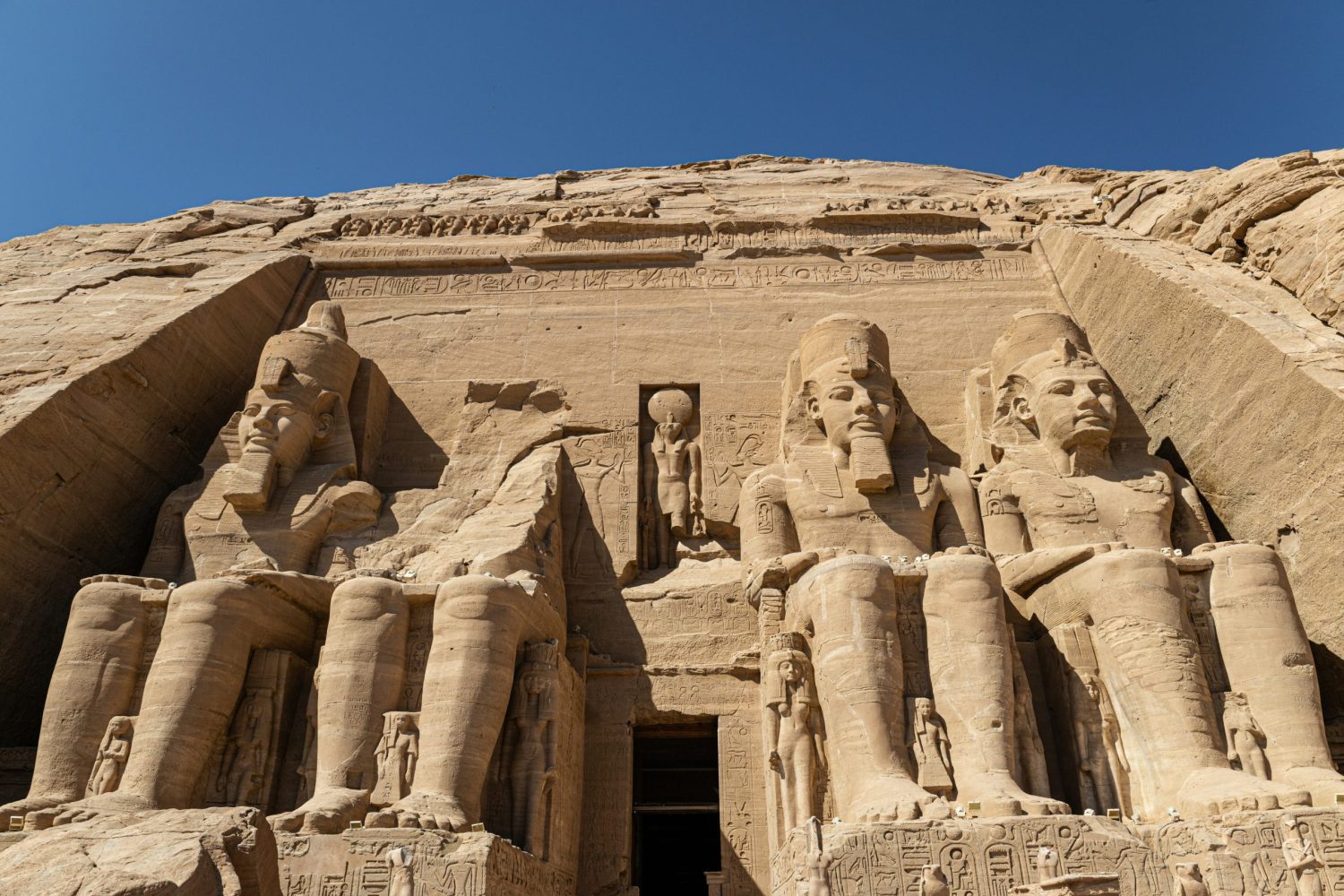 "El Crucero por el Nilo de Lujo MS River Tosca visitando el majestuoso Templo de Abu Simbel, construido por Ramsés II en Asuán, destacando su arquitectura monumental y estatuas colosales."
