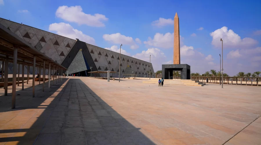 El Gran Museo Egipcio En Giza visto desde el exterior con su arquitectura moderna y fachada de vidrio translúcido.