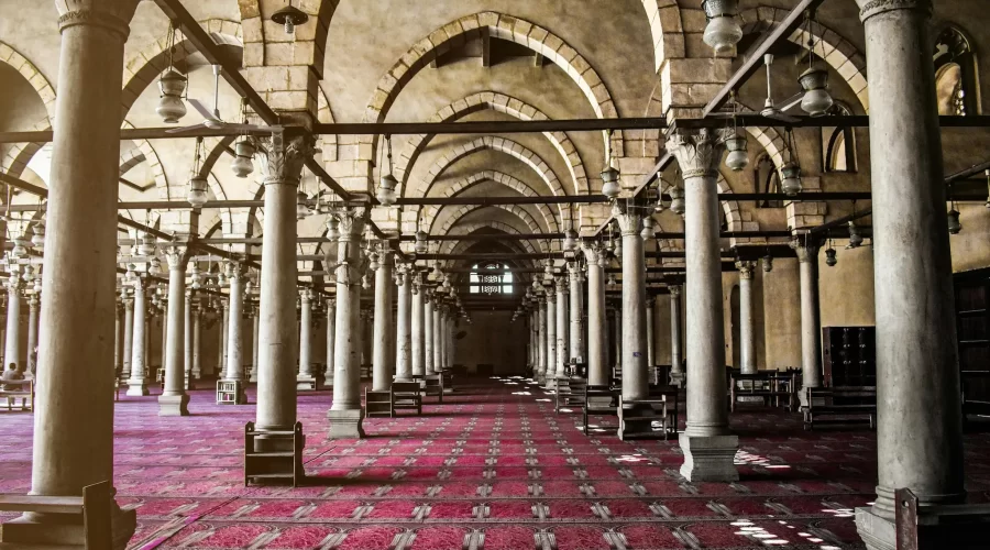 Vista colorida del patio de La Mezquita de Amr Ibn Alas en El Cairo con columnas históricas y arquitectura islámica antigua